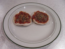 Pizza sauce and seasonings on toasted english muffins